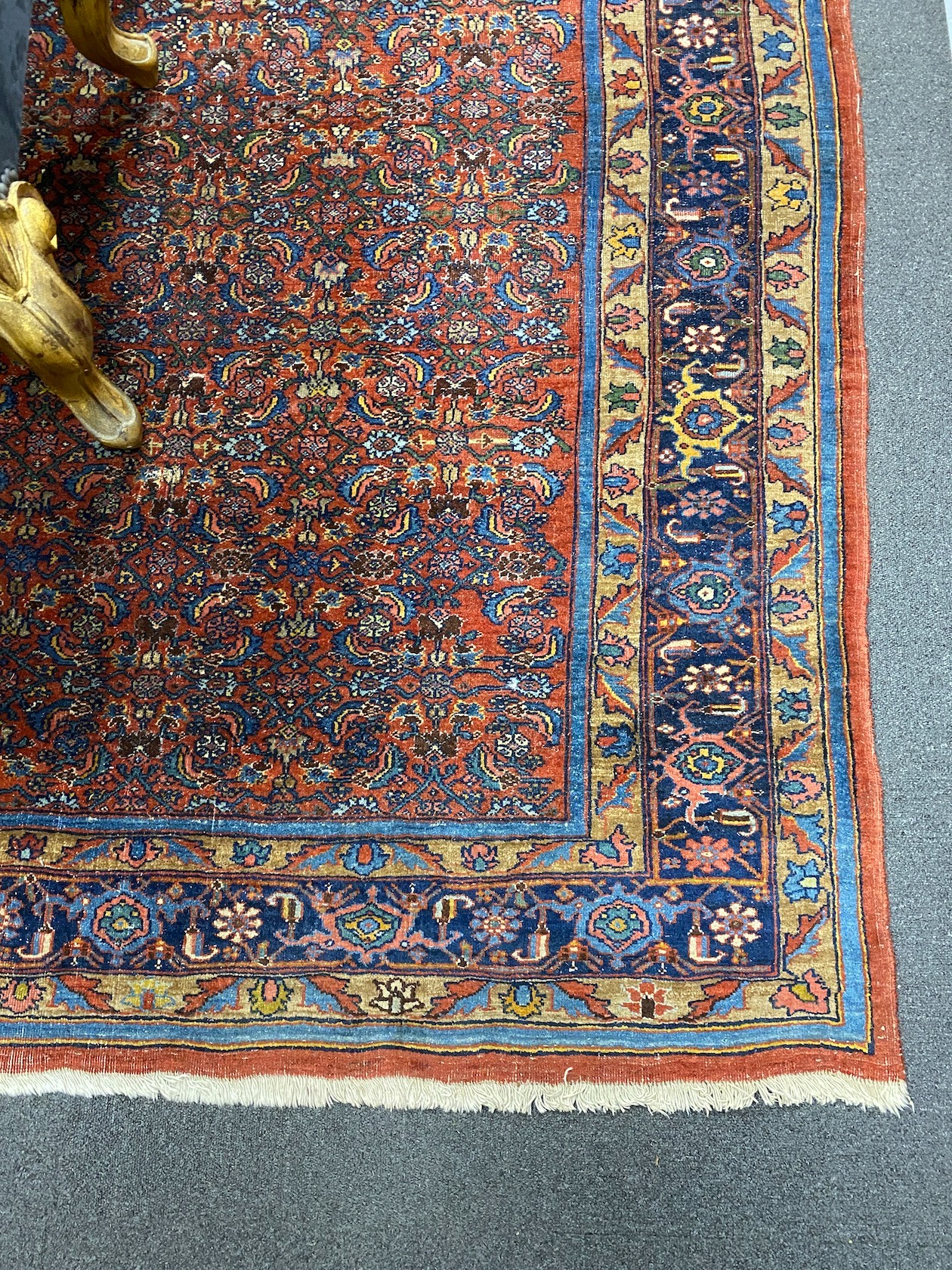 A North West Persian red ground carpet with dense floral field within a triple border, 360 x 250cm